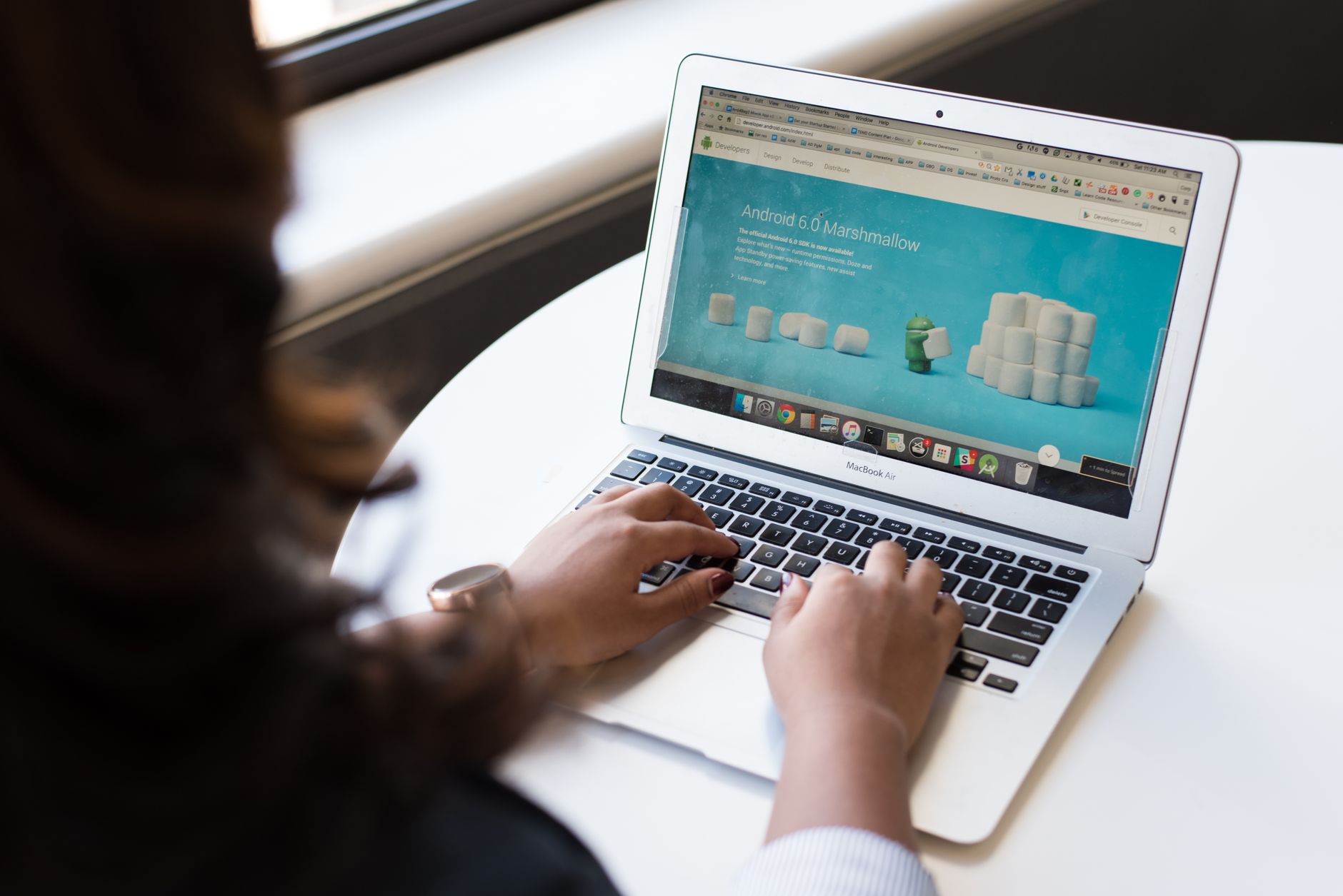 Businesswoman working on laptop with Android 6.0 Marshmallow webpage open. — Imported Article