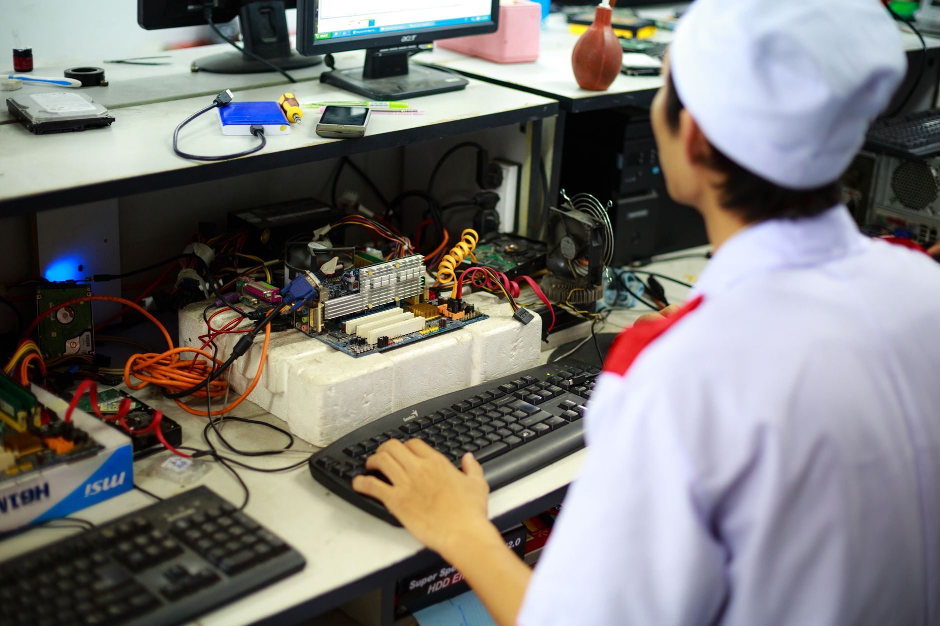 A technician in uniform working on a motherboard at a desk in a laboratory setting. — Key Services Offered by a Public Relati