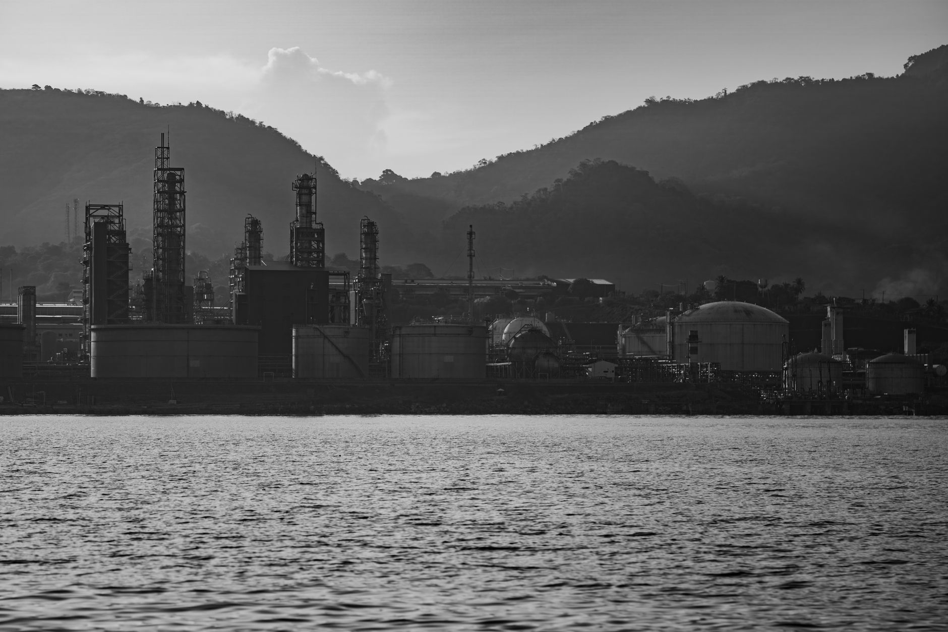 Black and white image of an industrial plant by the water with a mountain backdrop. — Participants quickly adapt to virtual s