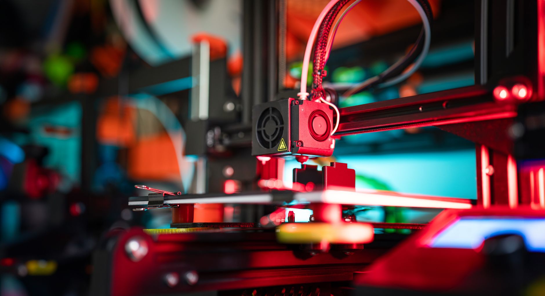 Close-up of a 3D printer operating in a vibrant red and teal laboratory setting. — Precision Optimization Strategies That Ele