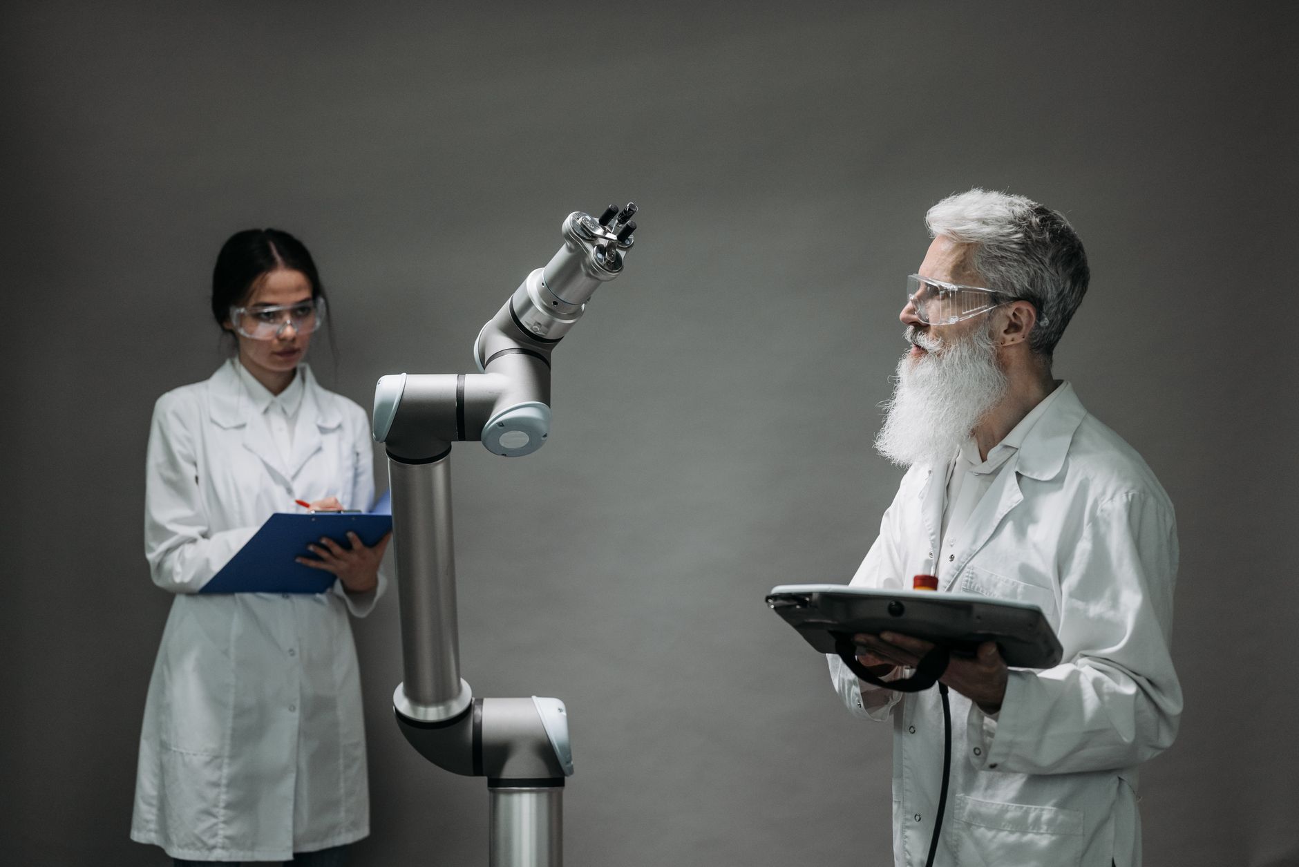 Two scientists working with a robotic arm in a lab setting, focusing on innovation and technology. — Student Travel in Hull M