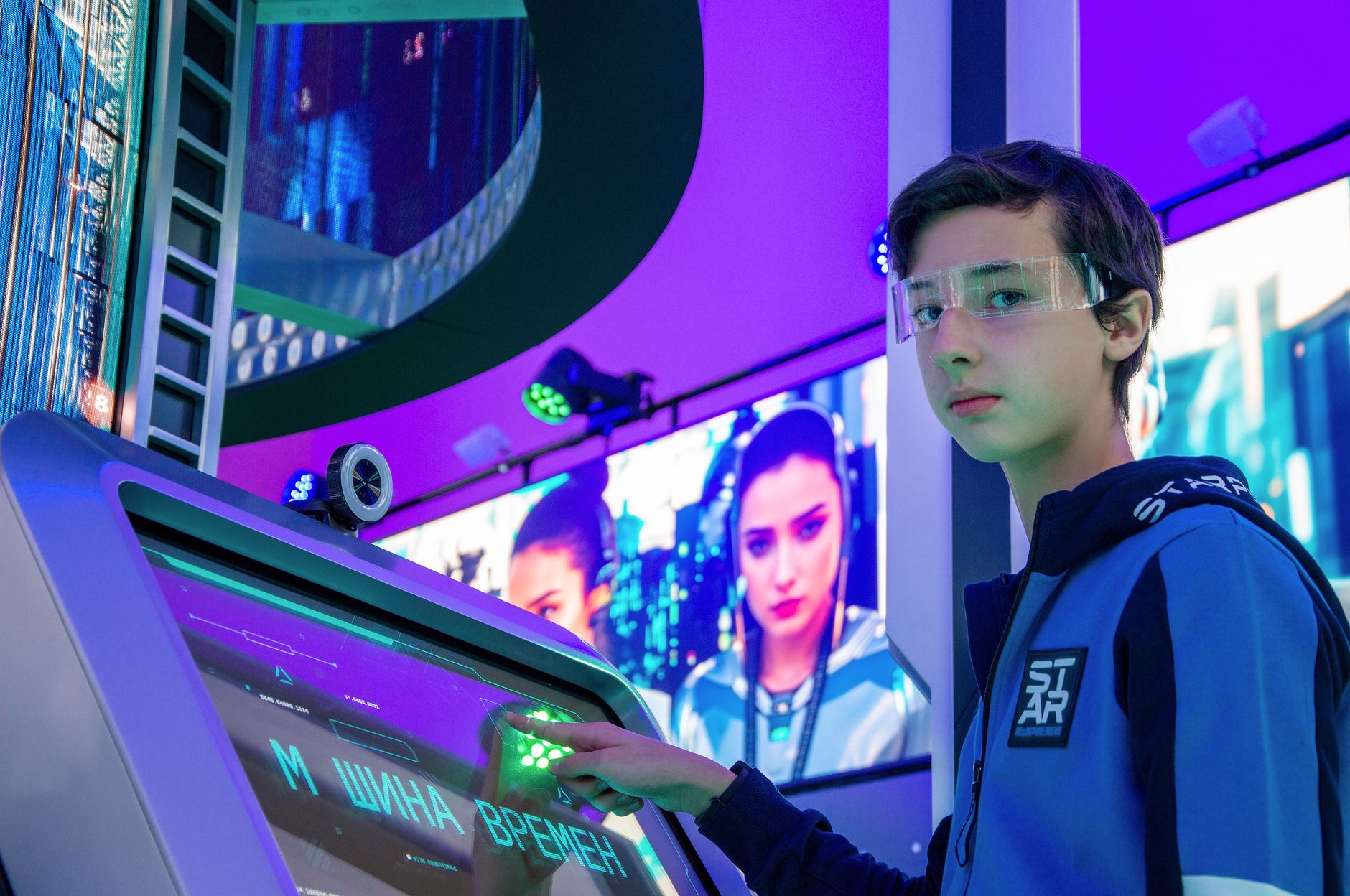 Teen boy in a digital room interacting with a futuristic touchscreen device wearing protective goggles. — Technology Redundan